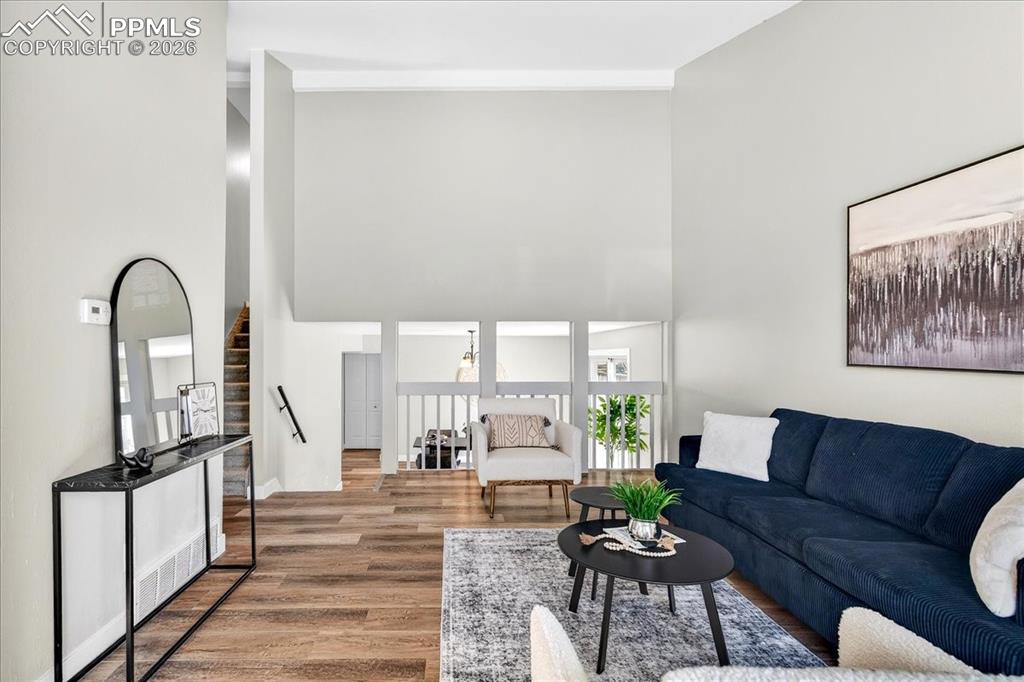 Image 6 of 49: Living room with wood finished floors and a high ceiling
