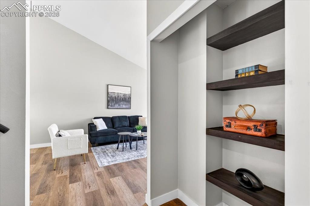 Image 7 of 49: Hallway with light wood-type flooring and vaulted ceiling