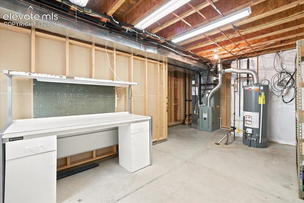 Image 37 of 50: Furnace and water heater are in the Unfinished work space in the basement