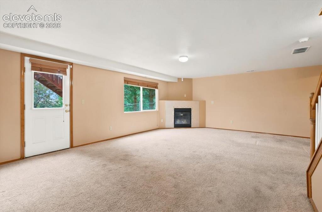 Image 43 of 50: There is a gas fireplace in the basement living room