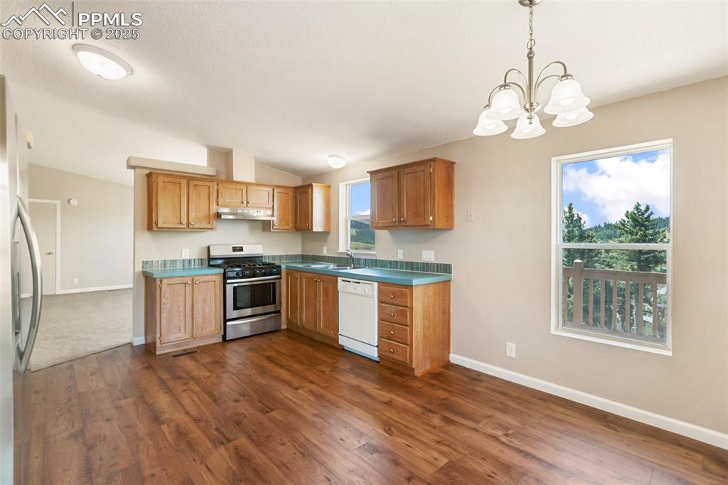 Image 12 of 38: Glass tile backsplash and new LVP flooring.