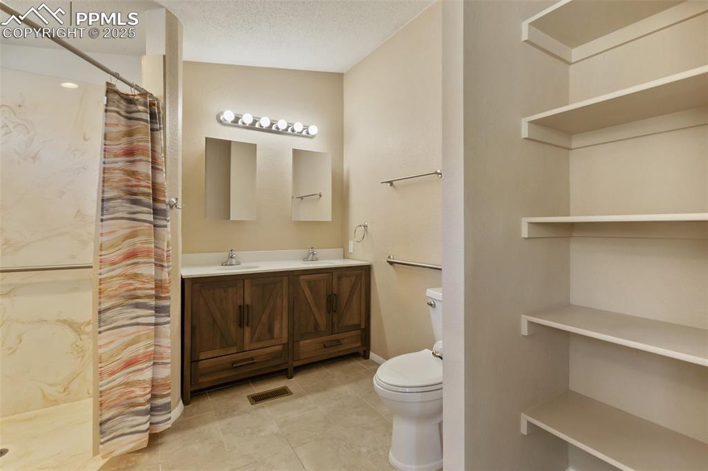 Image 29 of 38: Primary ensuite bathroom. Tile flooring and handicapped accessible walk-in