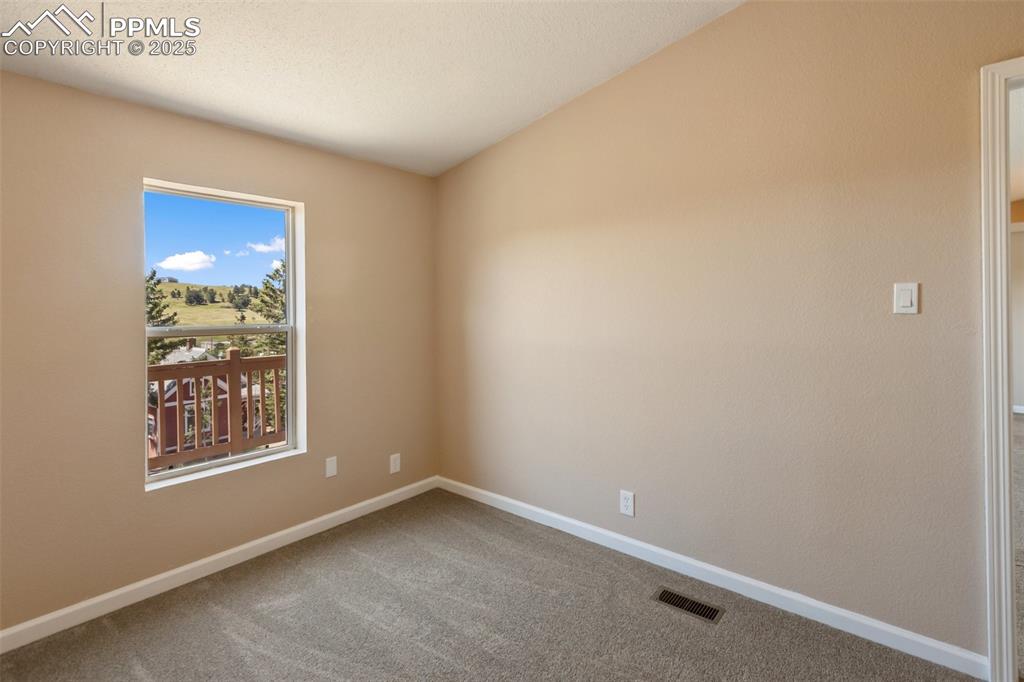 Image 33 of 38: 3rd bedroom with flow to the living room. Wake up to hillside views to the