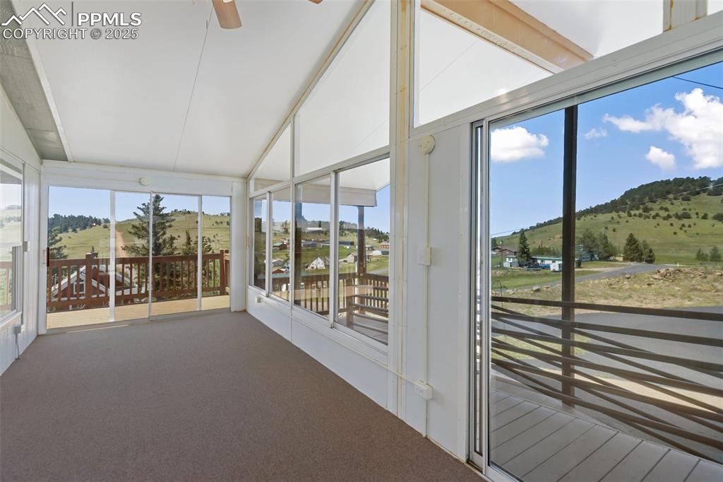 Image 9 of 38: Screened and windowed 9x 25 carpeted sunroom. Bring the fresh mountain air