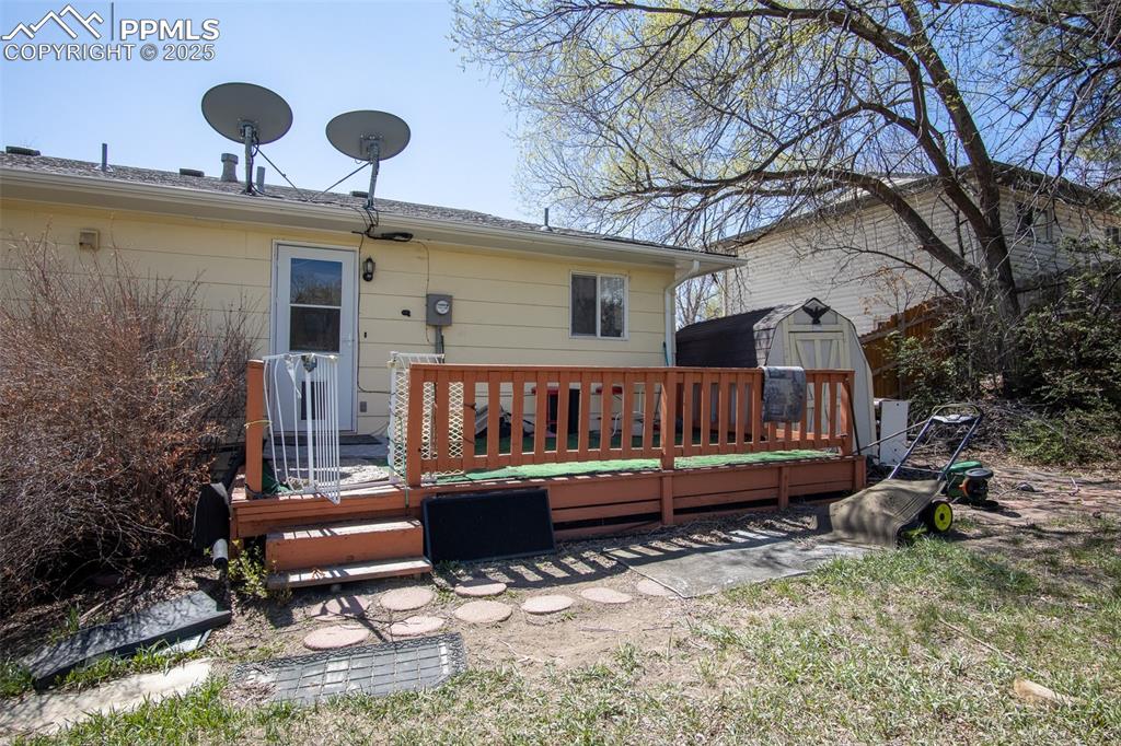 Image 41 of 44: Back of property featuring an outdoor structure, a wooden deck, and a shed