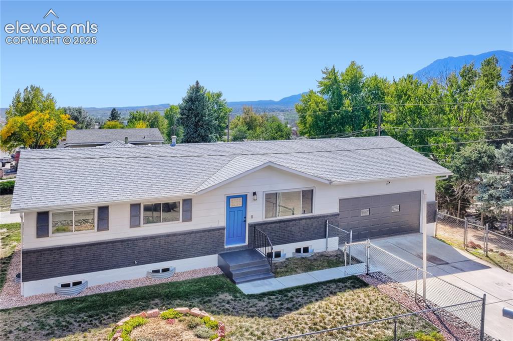 Image 1 of 42: White exterior with dark brick accents, a vibrant blue entry door, and a gr