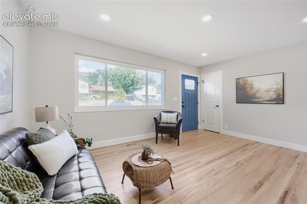 Image 10 of 42: Recessed lighting illuminates the open living space, featuring wood-finish 