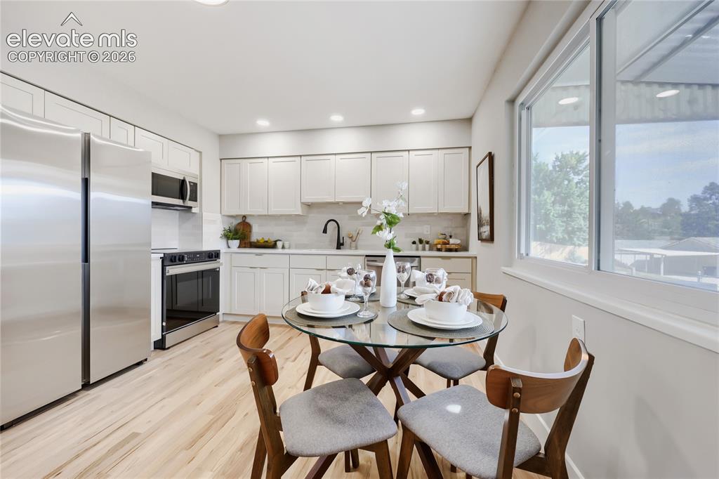 Image 13 of 42: Kitchen featuring stainless steel appliances, white cabinetry, light-toned