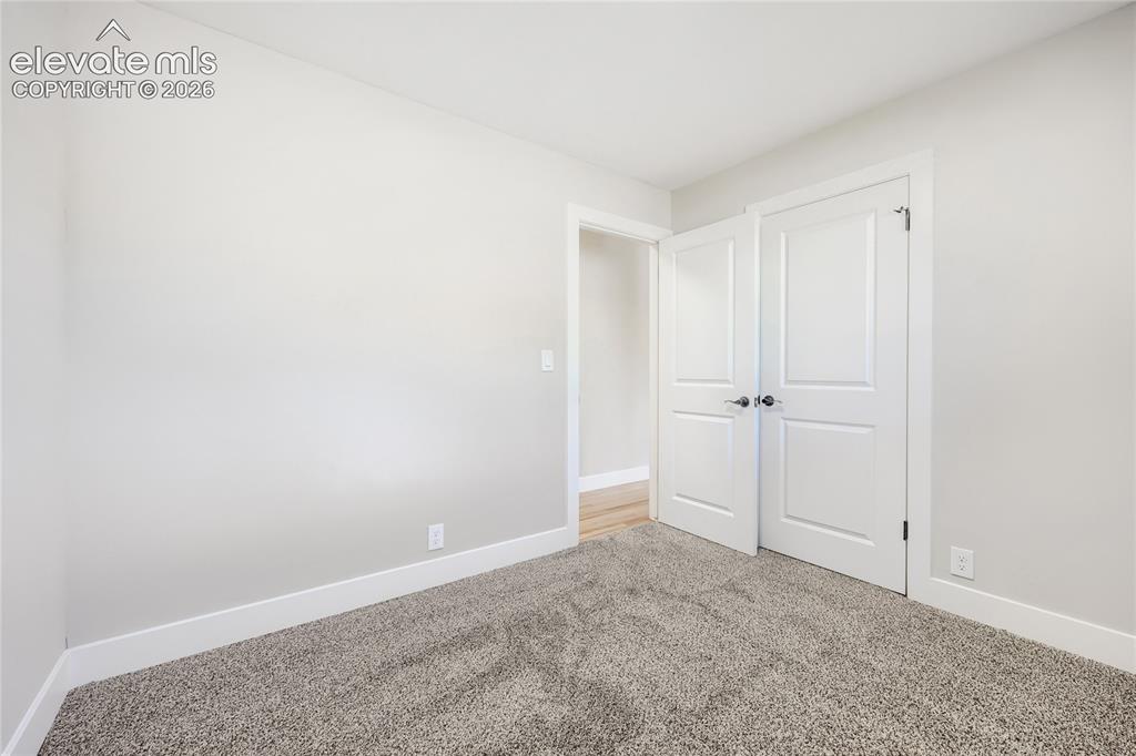 Image 20 of 42: Neutral-toned walls complement the grey carpet flooring