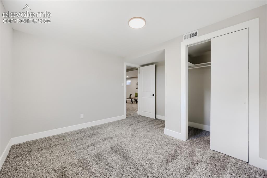 Image 28 of 42: Wall-to-wall carpeting, overhead flush-mount lighting, and white trim throu