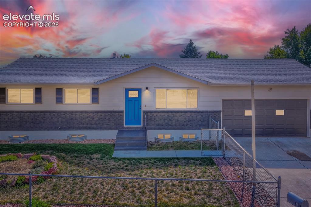 Image 3 of 42: Exterior featuring a blue entry door, an attached garage, a chain-link fenc
