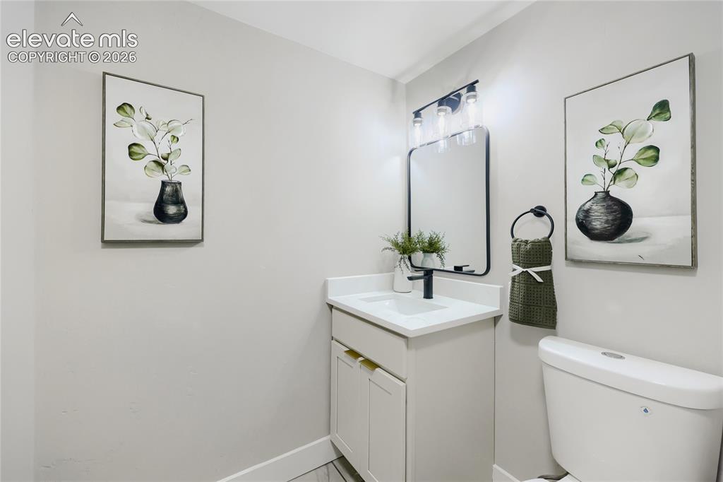 Image 30 of 42: White vanity with integrated sink, black framed mirror, and black wall-moun