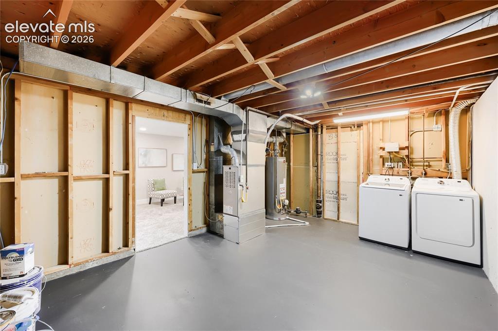 Image 31 of 42: Finished lower level space with exposed ceiling joists and painted concrete