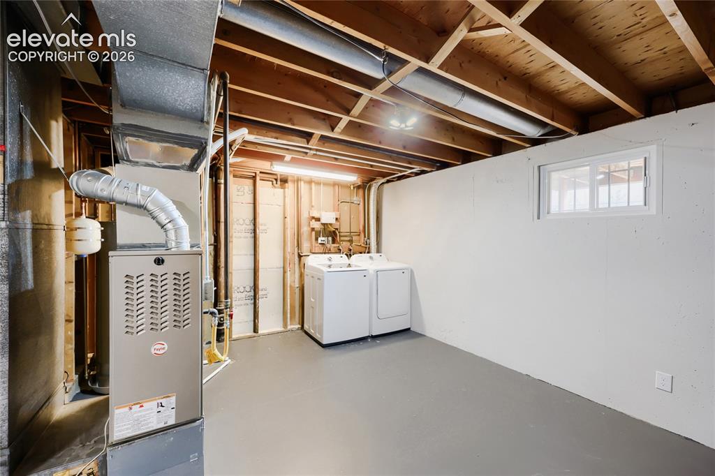 Image 32 of 42: Unfinished basement featuring a forced air furnace, exposed wood joists, pa