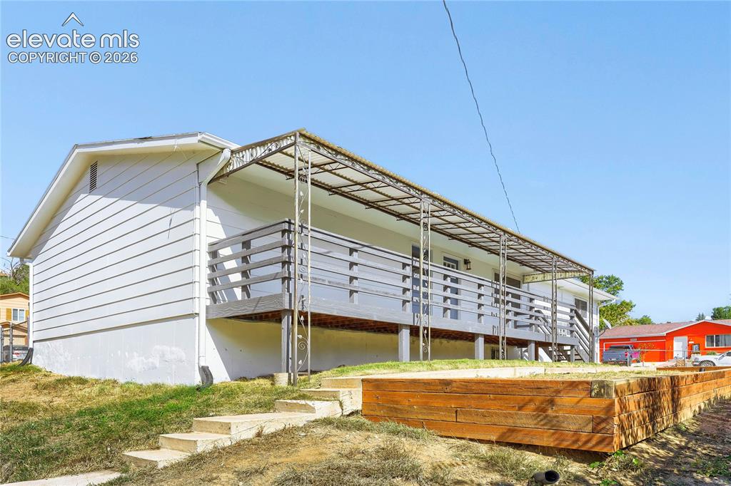 Image 33 of 42: Exterior featuring a covered balcony, wood-plank siding, concrete steps, an