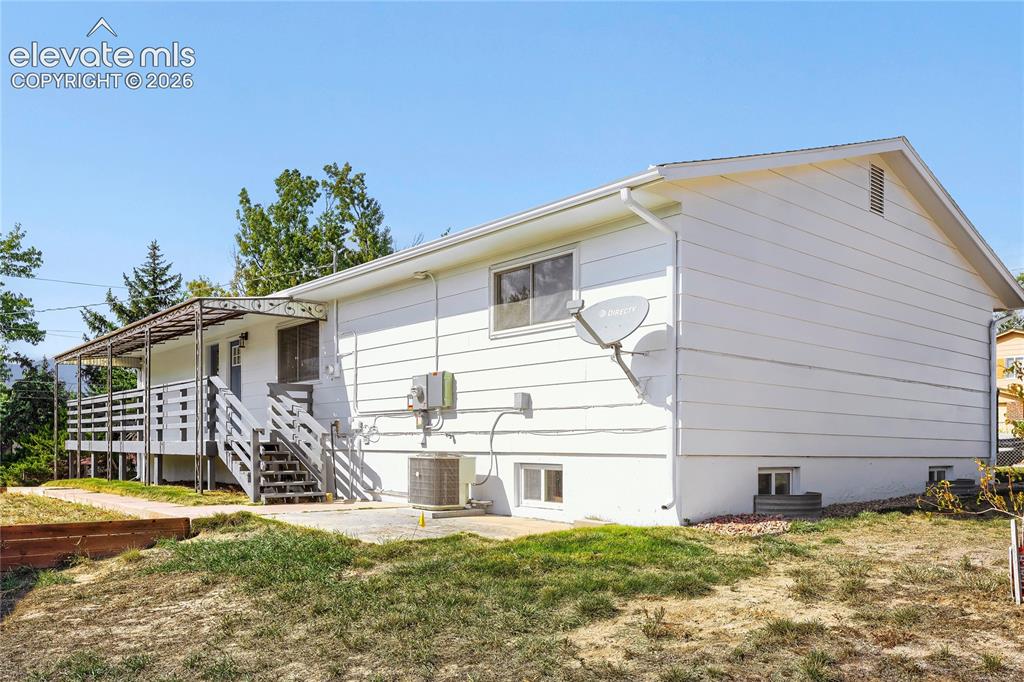 Image 38 of 42: Rear exterior featuring a covered deck, exterior staircase, lower-level pat