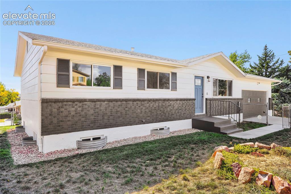 Image 7 of 42: Split-level exterior featuring white siding and a brick facade