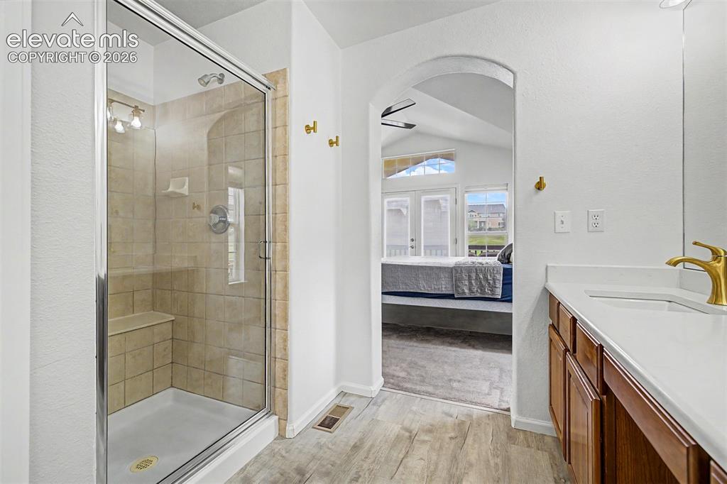 Image 17 of 33: The primary suite is a true retreat, featuring vaulted ceilings, a ceiling 