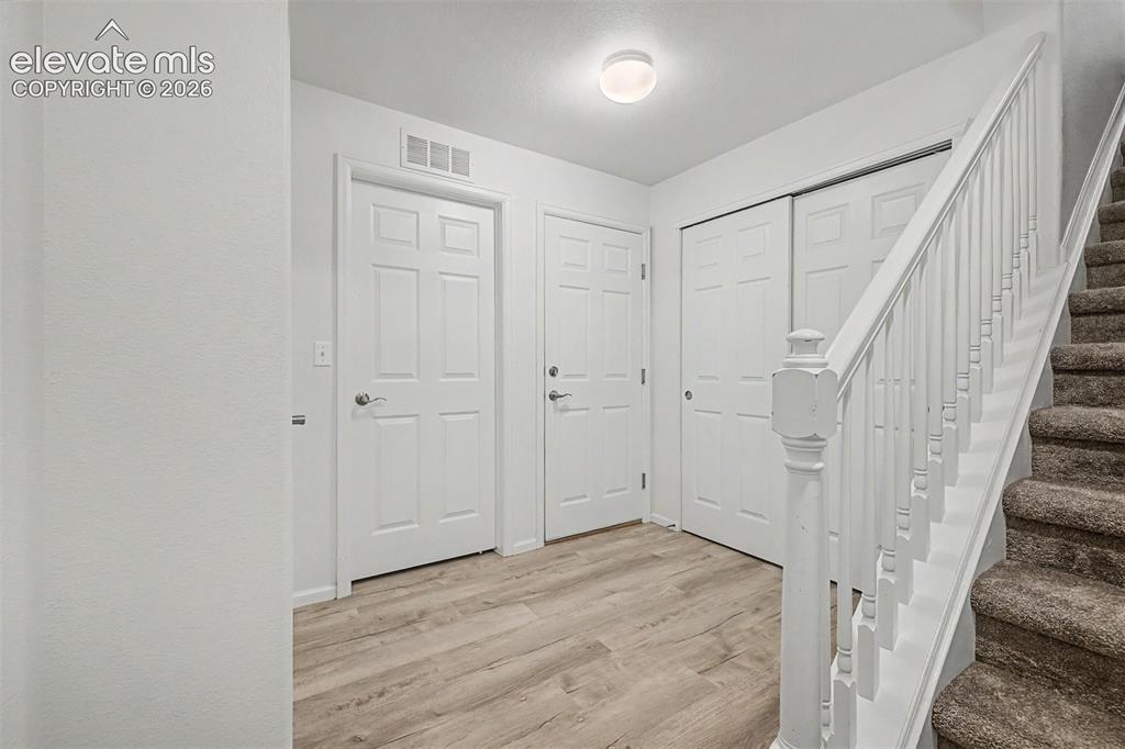 Image 22 of 33: A bright secondary bedroom features a dramatic arched window flooding the r