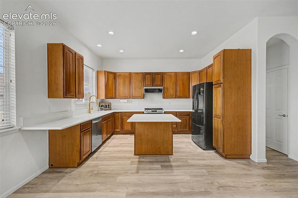 Image 6 of 33: The main living area shines with a tile-surround gas fireplace, soaring cei