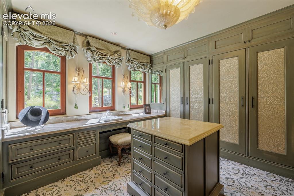 Image 14 of 49: Primary suite spa/bathroom with large soaking Jacuzzi tub and cabinetry wit
