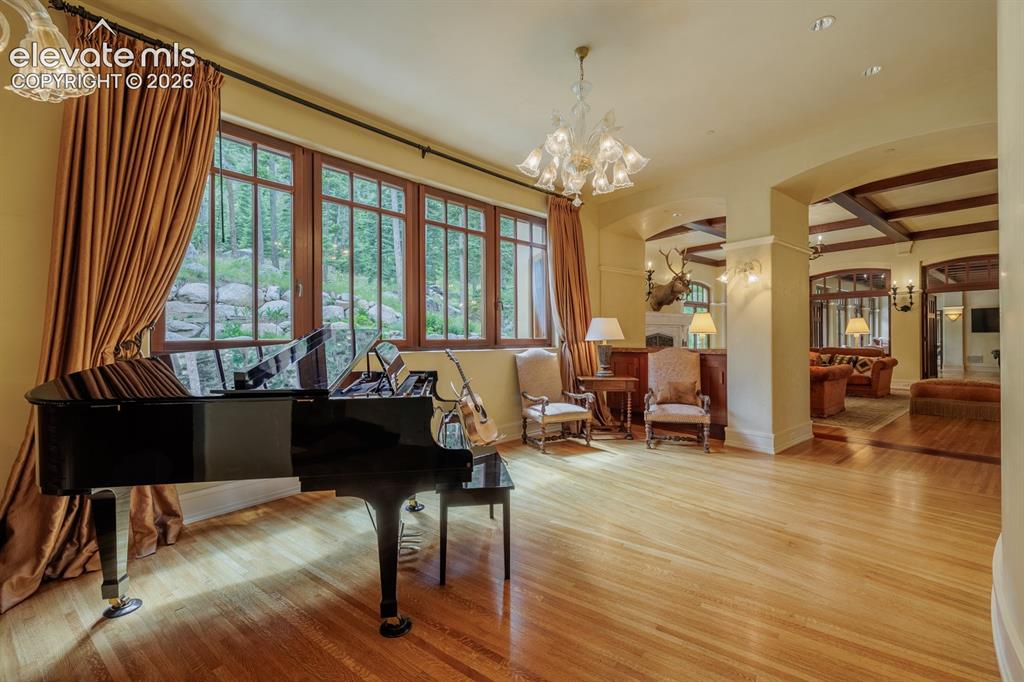 Image 31 of 49: African mahogany beams and limestone fireplace with rose quartz inlay