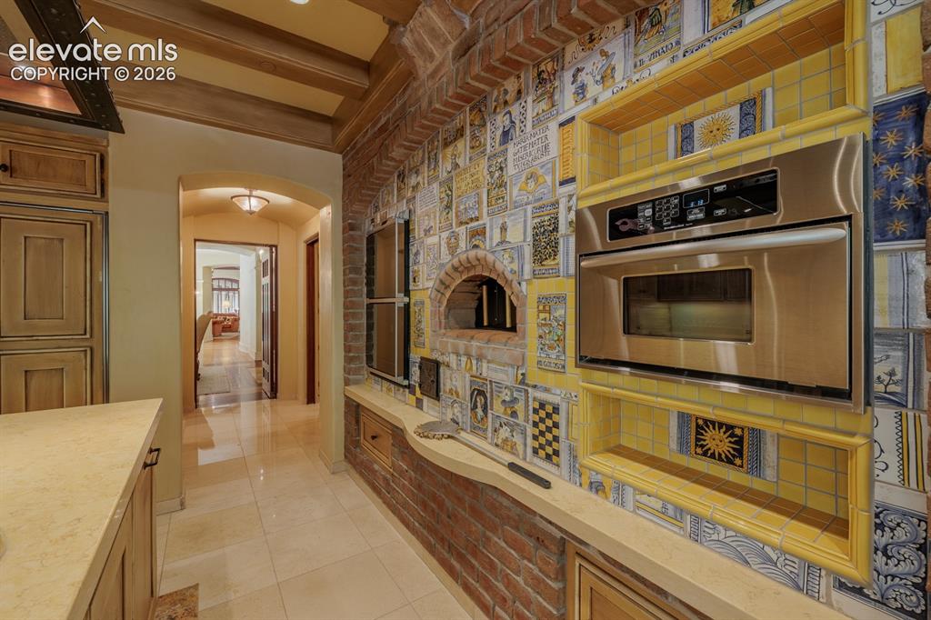 Image 34 of 49: Butlers pantry with dishwasher between dining room and kitchen. Main laundr