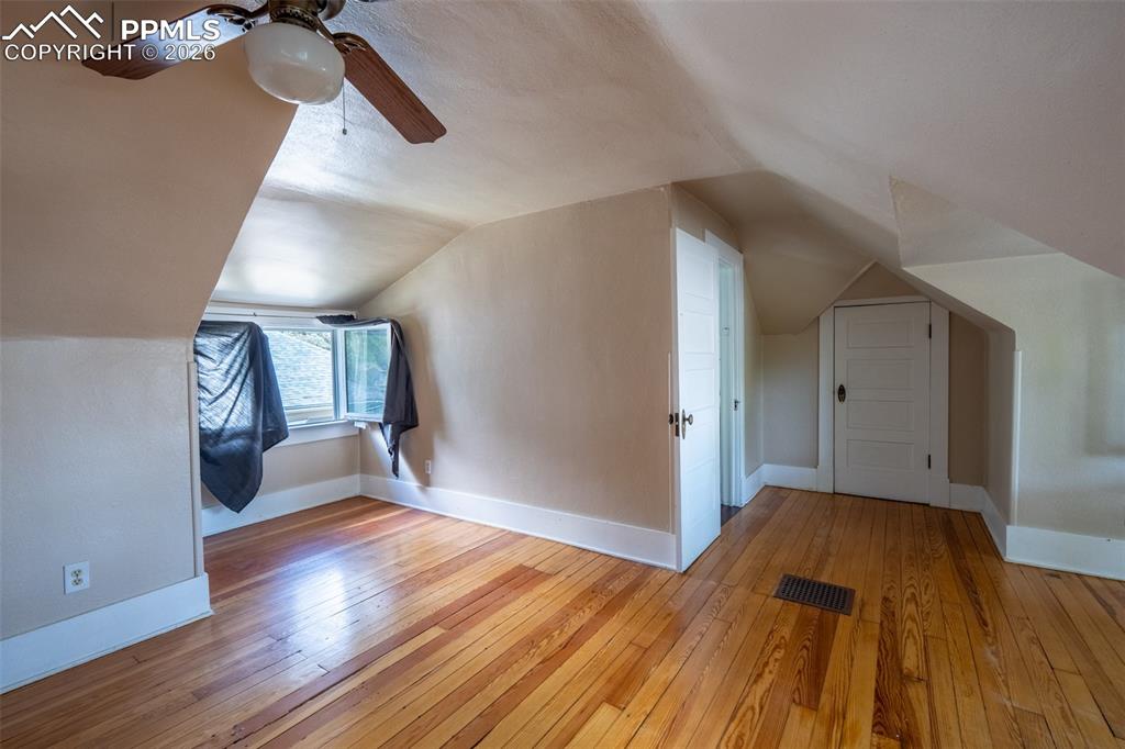 Image 16 of 24: Primary bedroom featuring light wood-style flooring, ceiling fan, and lofte