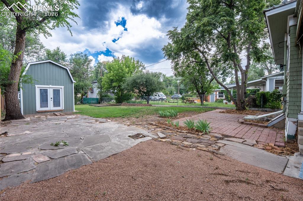 Image 23 of 24: View of yard featuring a patio, french doors, and an outdoor structure