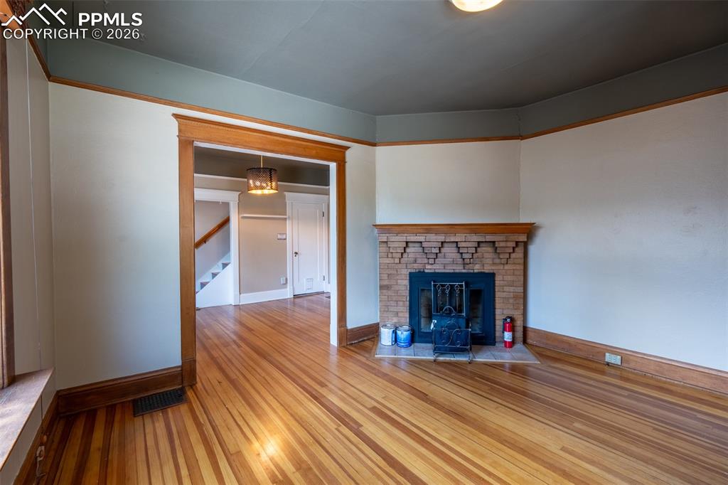 Image 4 of 24: Living room with light wood-type flooring and a fireplace
