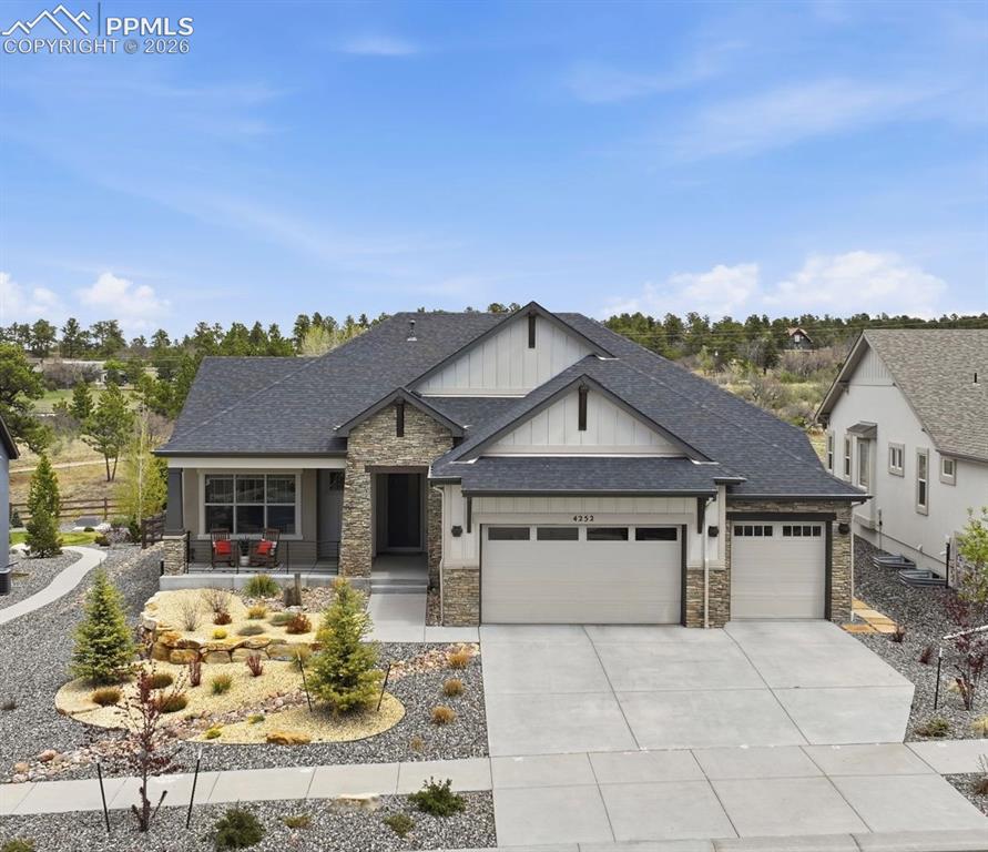 Image 1 of 39: Contemporary ranch-style home featuring stone and siding exterior, a three-