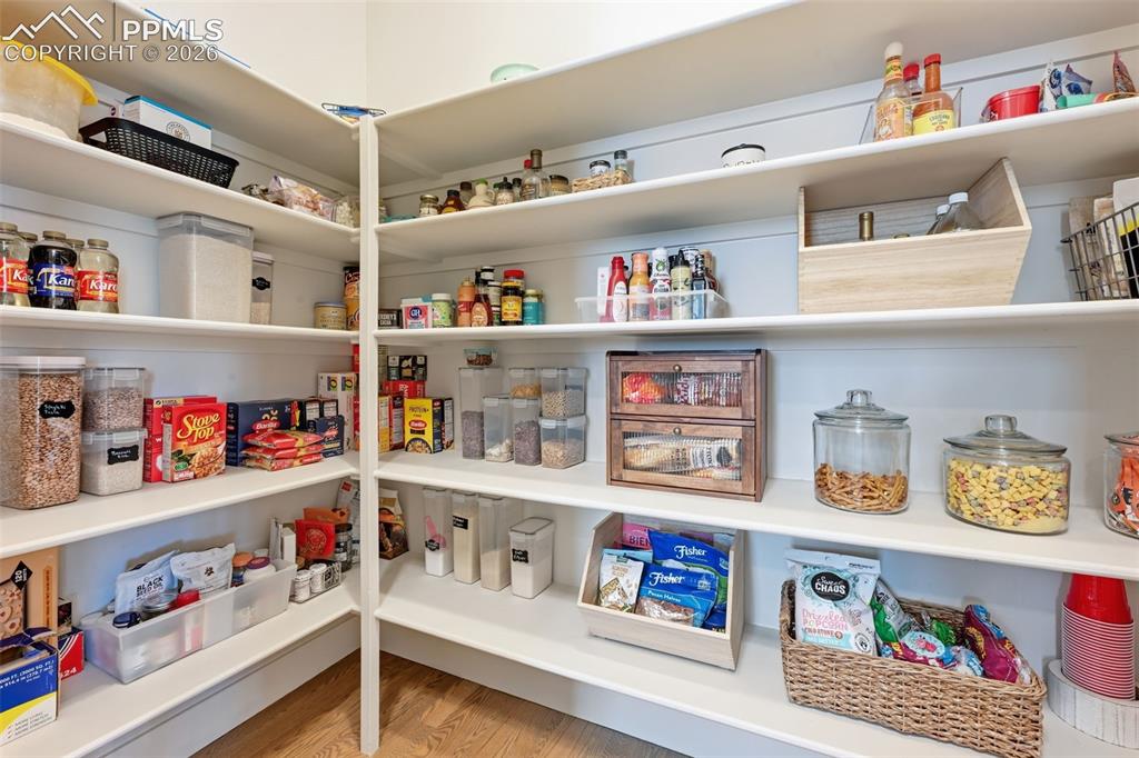 Image 13 of 39: Walk-in pantry #2 with extensive shelving, white painted finishes, and wood