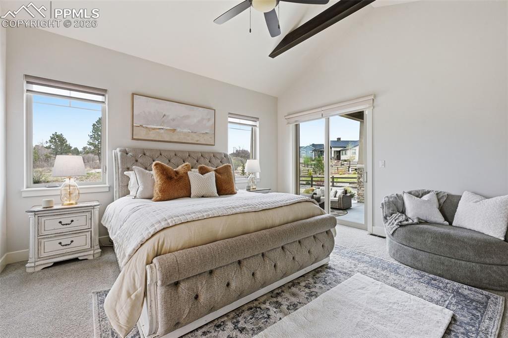 Image 15 of 39: Main level PrimarybBedroom featuring a vaulted ceiling with exposed beams, 