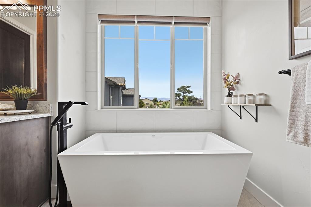 Image 17 of 39: Freestanding soaking tub with a floor-mounted matte black faucet, set again