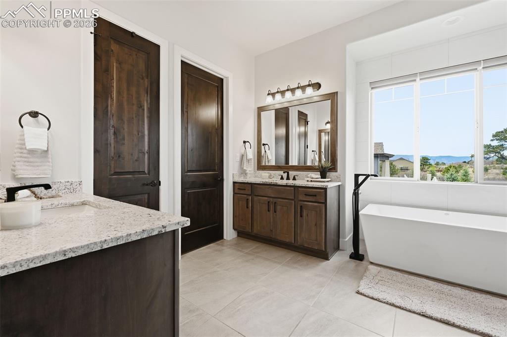 Image 19 of 39: Spacious bathroom featuring a freestanding soaking tub with a floor-mounted