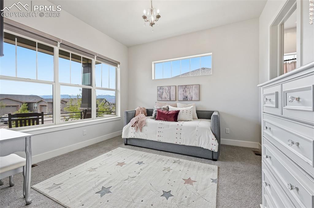 Image 23 of 39: Main level secondary suite; spacious interior featuring large windows with 