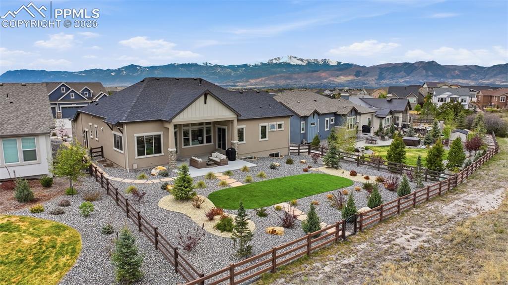 Image 3 of 39: Rear property exterior featuring a covered patio, extensive hardscaping wit