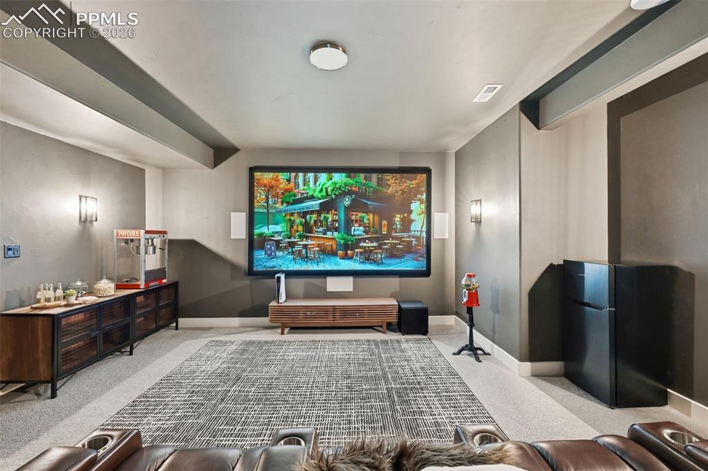 Image 32 of 39: Dedicated entertainment space featuring a large projection screen, built-in