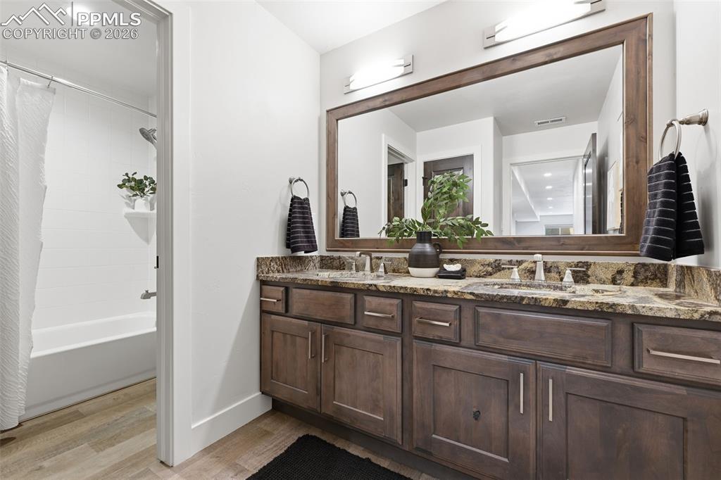 Image 35 of 39: Dual vanity with a stone countertop and undermount sinks