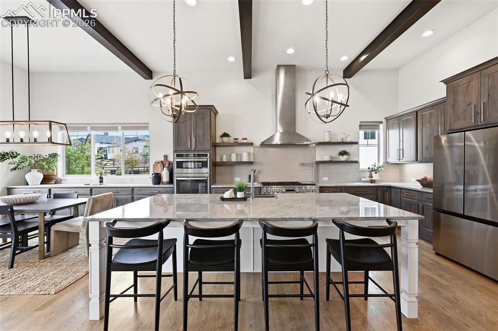 Image 9 of 39: Open-concept kitchen featuring an expansive island with seating, stainless 
