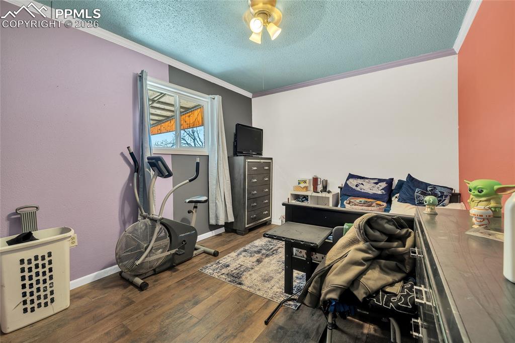 Image 15 of 49: Bedroom with dark wood-style floors, a textured ceiling, a closet, and crow