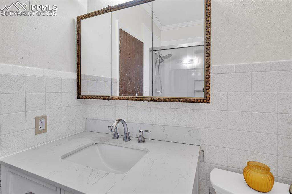 Image 16 of 49: Exercise area with dark wood-style flooring, a textured ceiling, ornamental