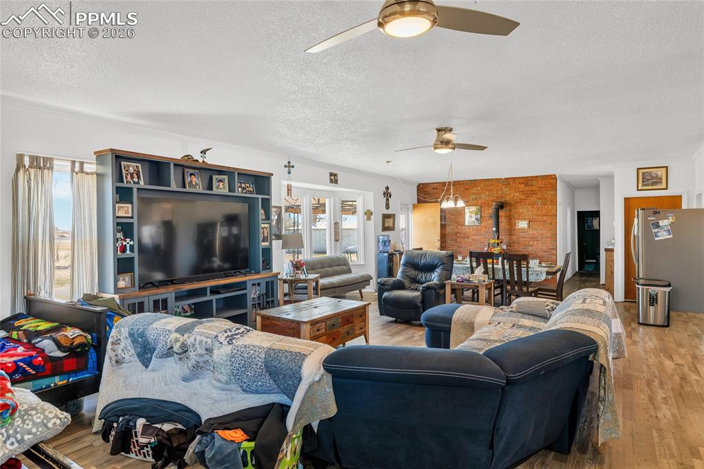 Image 24 of 49: Living room with ceiling fan, dark wood-style flooring, a textured ceiling,
