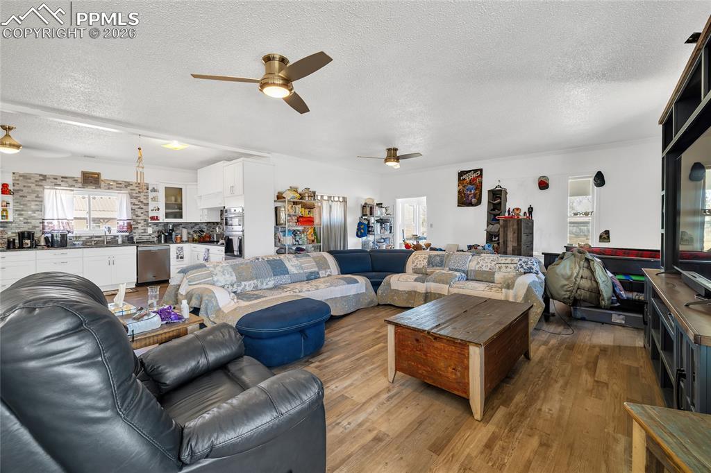 Image 25 of 49: Living room featuring wood finished floors, a textured ceiling, and ceiling