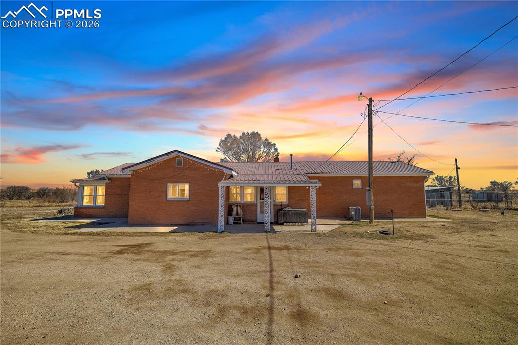 Image 3 of 49: View of front of house featuring a metal roof, stucco siding, and a chimney