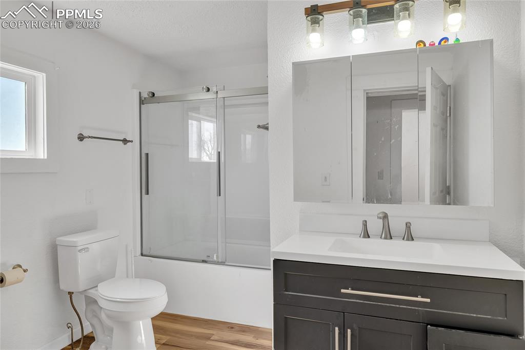 Image 35 of 49: ADU Laundry area featuring stacked washer / dryer and light wood-style floo