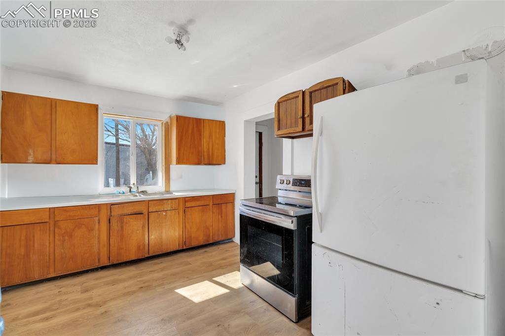 Image 37 of 49: ADU Kitchen with stainless steel range with electric stovetop, wood finish