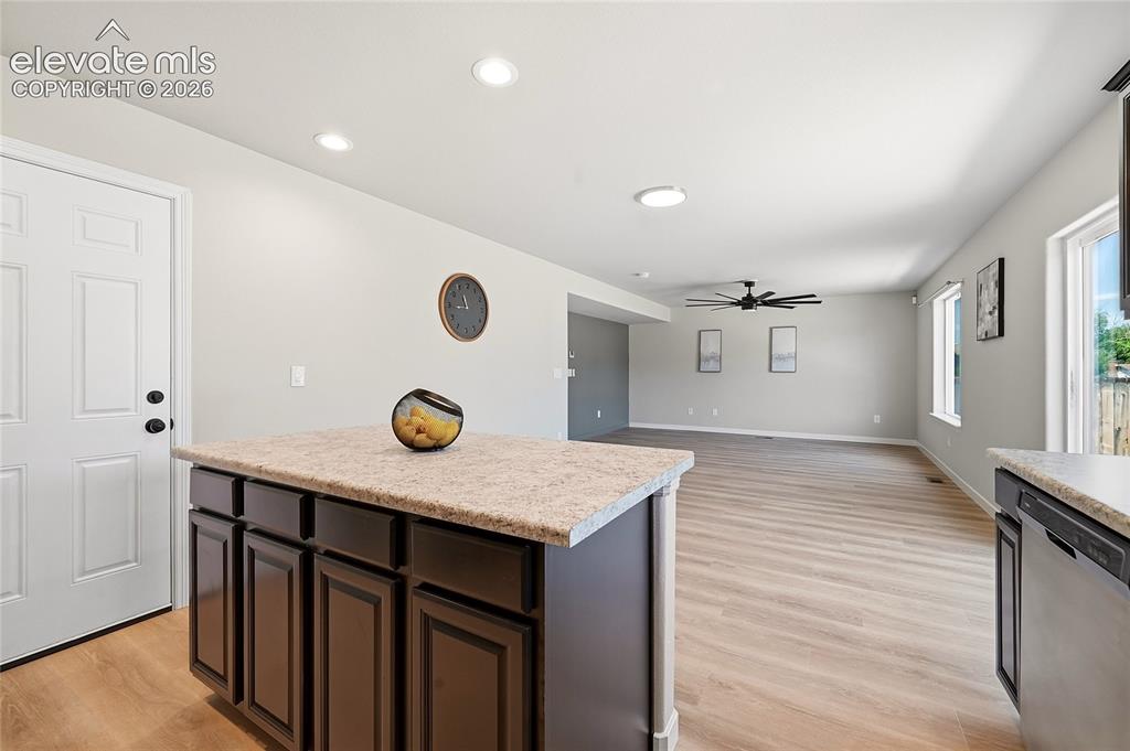 Image 11 of 30: Open-concept living space featuring wood-finish flooring, recessed lighting