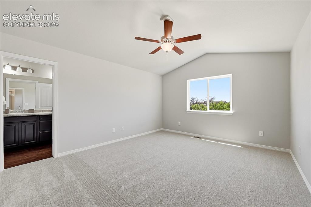 Image 15 of 30: Spacious room featuring vaulted ceilings, light gray wall tones, and neutra