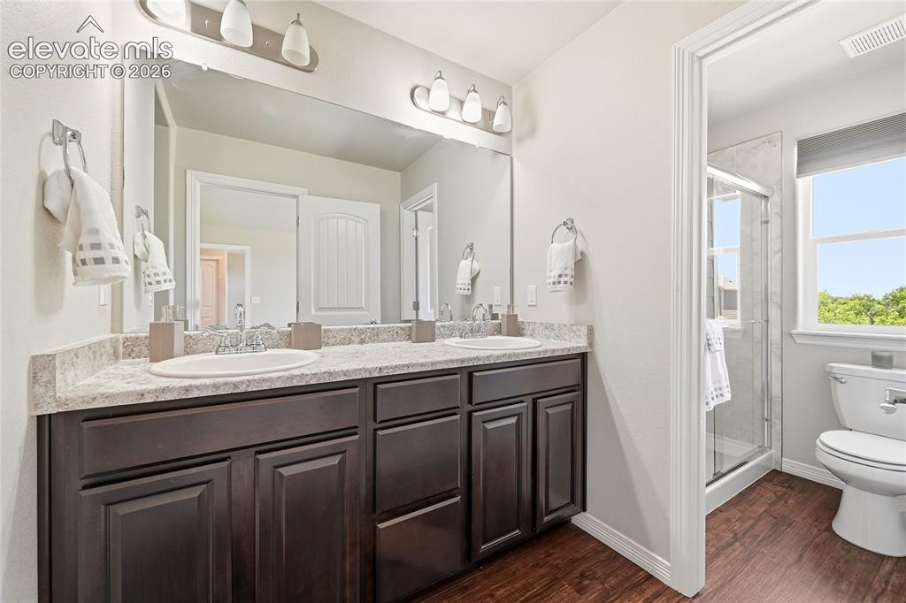 Image 17 of 30: Double vanity featuring dark wood cabinetry, white oval sinks, and a speckl